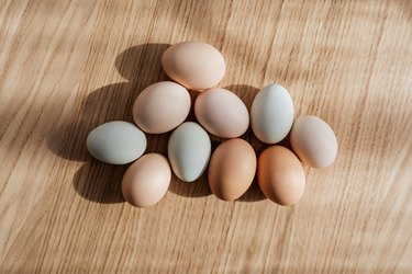 multicolored eggs on light wood surface