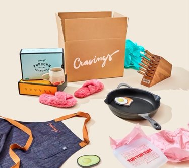 cravings by chrissy teigen box, spice kits, apron, frying pan, knives, slippers, and reusable bag