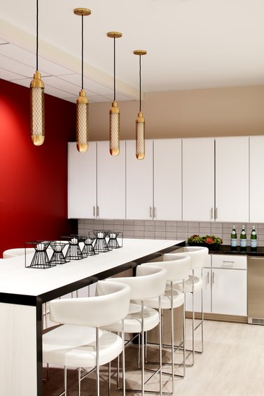 kitchen area with island, white chairs, and hanging light fixtures