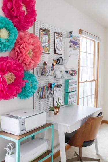 white office with several brightly hued tissue flowers