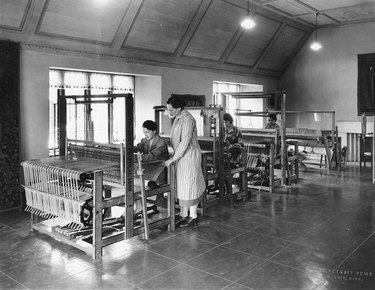 black and white photo of people standing in a weaving studio