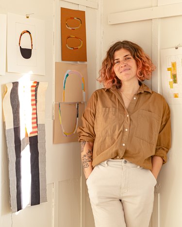 designer sara berks in front of white wall with art