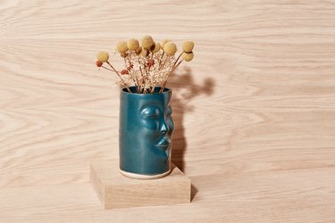 Green ceramic vase with dried billy buttons
