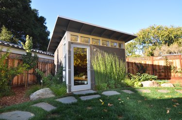 Contemporary shed with square metal siding, windows, and geometric roof