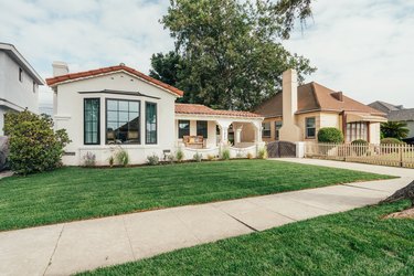 A Spanish-style home with a green front lawn