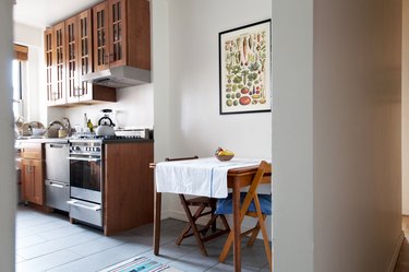 apartment size stove in kitchen with wood cabinets