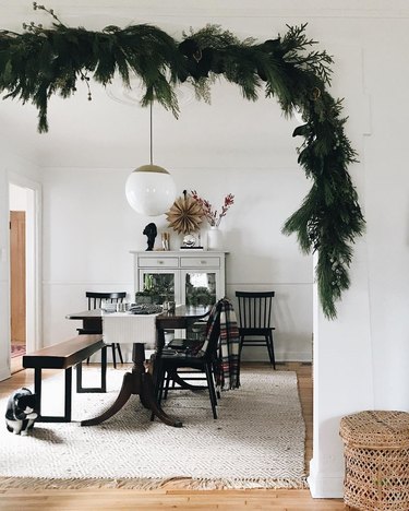 contemporary Christmas decor with garland hung in the doorway to dining room