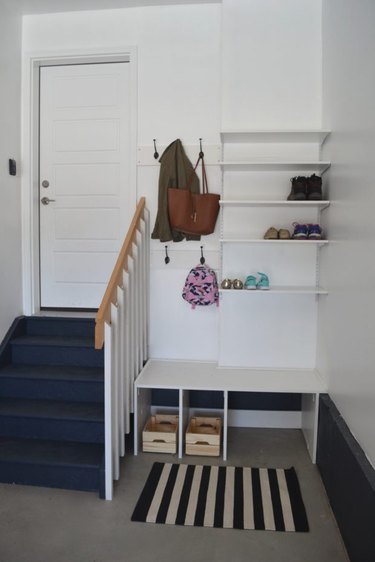 small garage mudroom with rug and shelves