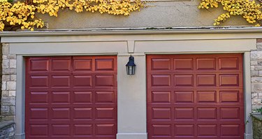Dark red garage door colors on stone house.