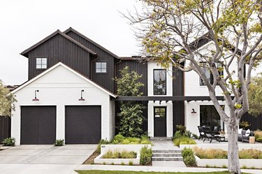 Black garage door colors on white modern farmhouse with double garage.