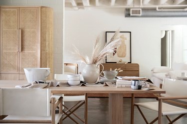dining table with dinnerware and white furniture in the background