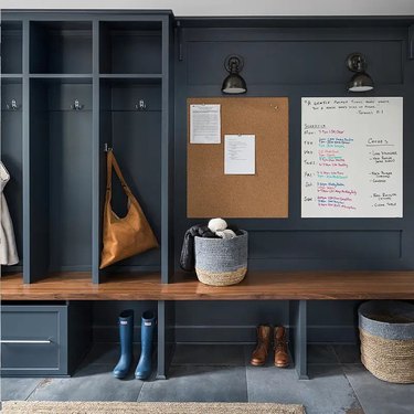 gray garage mudroom with wooden in-built bench and noticeboard
