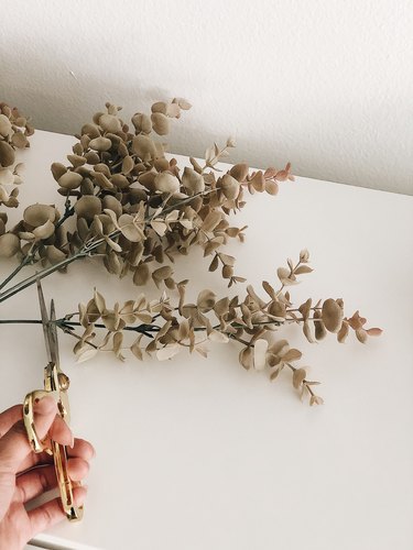 Cutting faux eucalyptus stems.