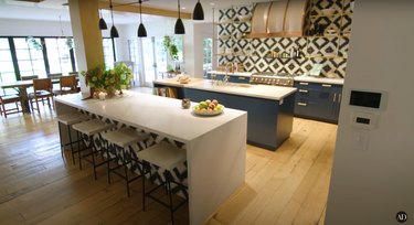hilary duff's kitchen with black and white backsplash, kitchen island, and bowl of fruit