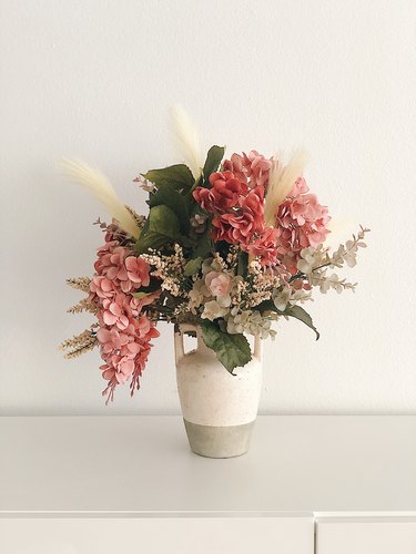 Faux flowers in a rustic vase