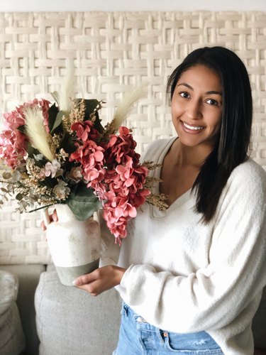 YouTuber Nastazsa holding faux flower arrangement.