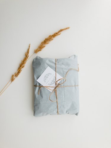 gift wrapped in brown twine with note card and wheat leaves