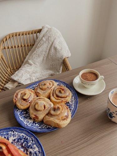 cinnamon rolls and warm drinks on table