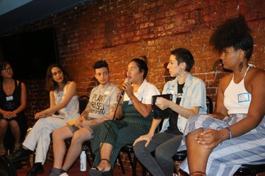 group of people sitting in front of brick wall