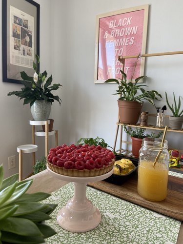 pie on stand with decor and plants in background