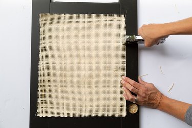 Stapling cane to a black panel on an IKEA cabinet