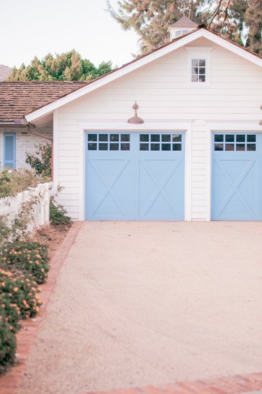 light blue garage door on white house exterior