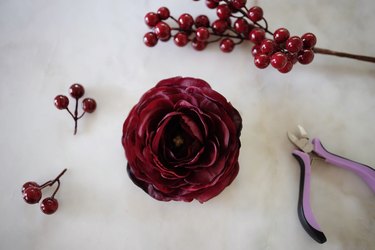 Faux ranunculus and berries clipped off their stems