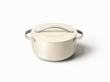 White ceramic nonstick cookware Dutch oven with silver handles on white background