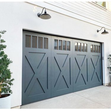 white house with farmhouse style blue garage doors