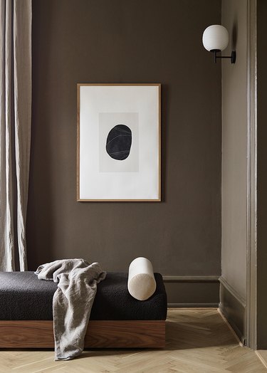 Living room with brown walls and black chaise