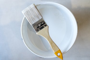 Isolated bristle brush with white paint pot