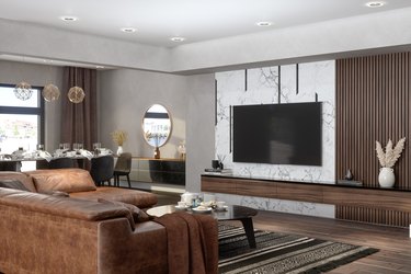 Luxury living room with leather sectional, TV, and dining table.