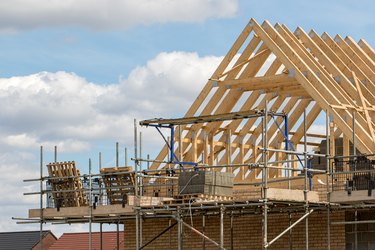 Construction industry. Timber framework of house roof trusses with scaffold.