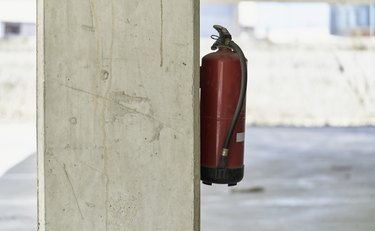 A fire extinguisher placed in a column