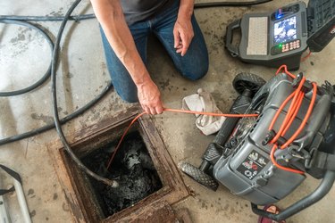 Inspecting the damage on a home sewer pipe