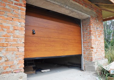 Installing garage door in new brick house construction.