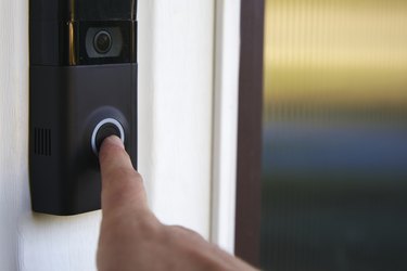 Close up POV shot of a person ringing a smart doorbell