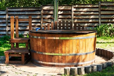 Modern wooden hot tub with stairs in garden.