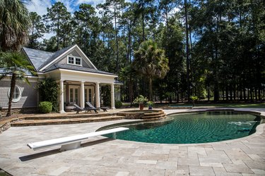 Custom pool House behind a landscaped estate with a large swimming pool and hot tub