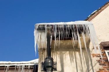 Icicles Hanging from a Mansion Roof against Clear Blue Sky