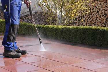 Cleaning patio pavers with power washer.