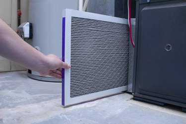 Changing an air filter on a high-efficiency furnace.