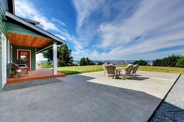 View of large concrete patio area in backyard.