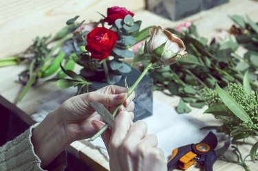 Florist at work assembling the bouquet of tulips in a hat box