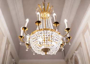Beautiful chandelier hanging from ceiling with classic gold plated fixtures