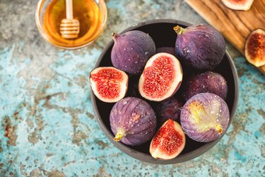 Fresh figs and honey on rustic background.