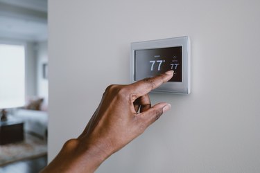 Woman Adjusts Thermostat