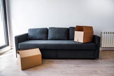 sofa in an empty room with two cardboard boxes