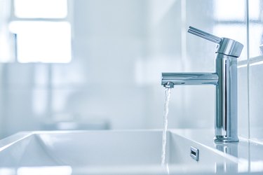 Modern sink, open tap.