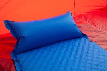 A blue self inflating blow-up mattress pad